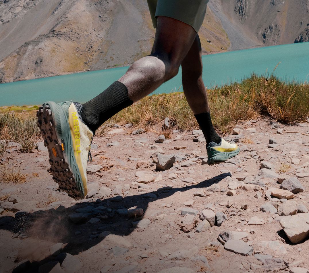 Person tying Merrell running shoes